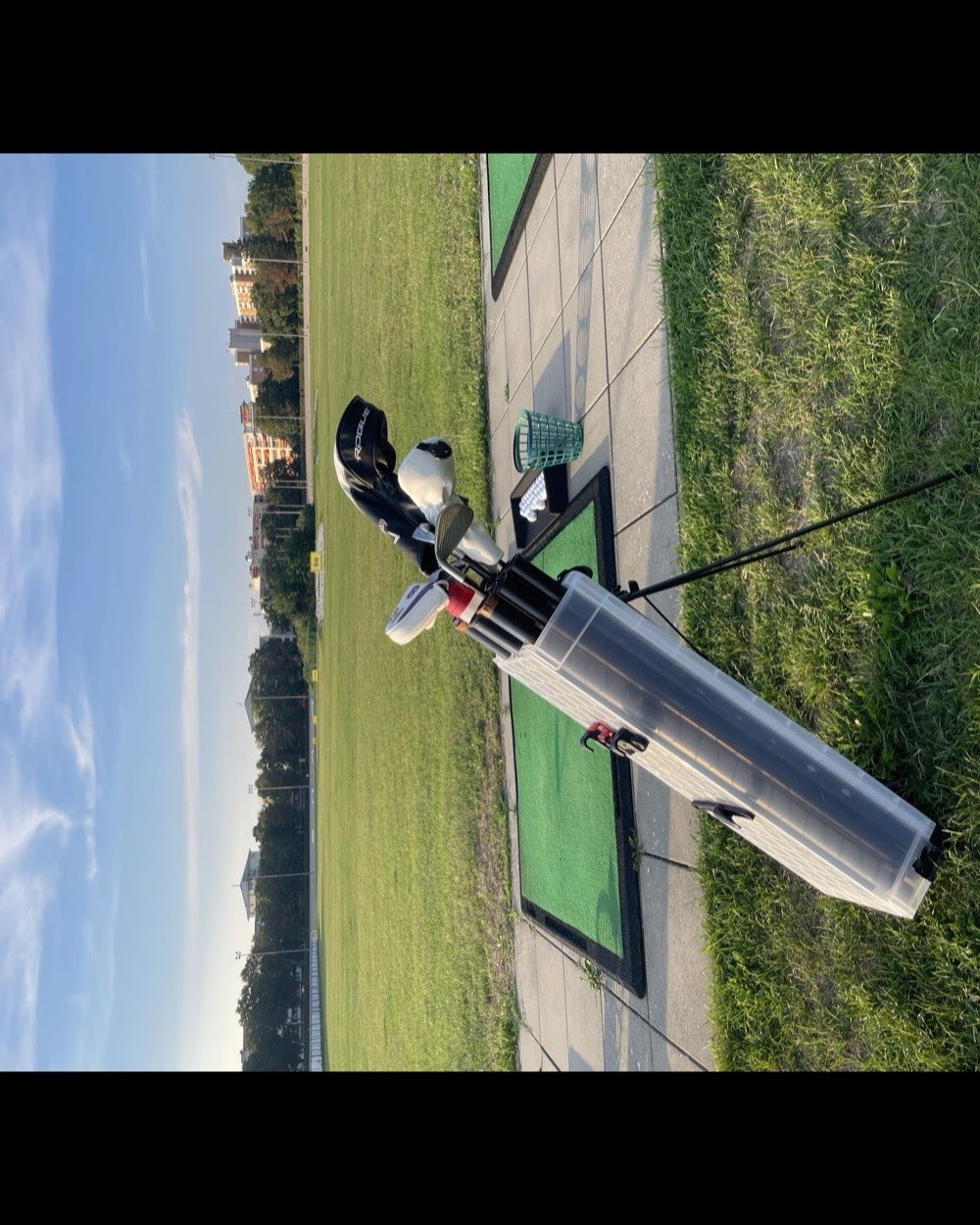 The prototype standing beside the artificial practice mats under a blue sky, city skyline in the distance.