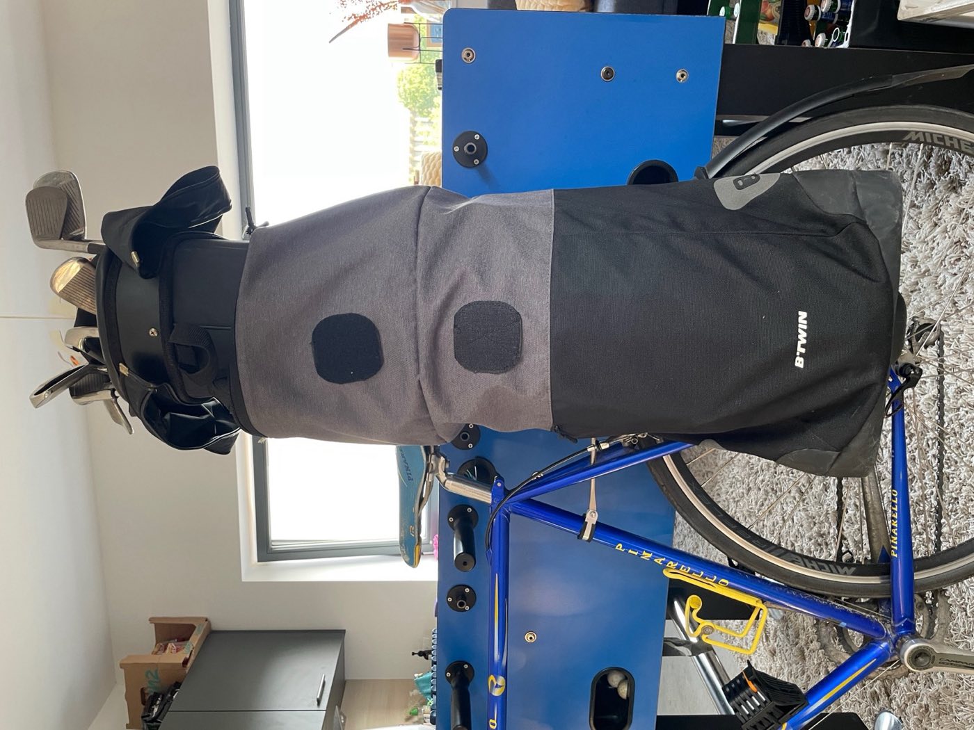 The v2 prototype mounted on a bike: a grey bicycle pannier joined to a golf bag top with round velcro patches.